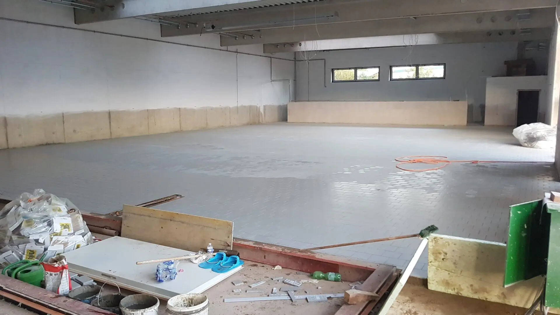 Neu ausgeführter Estrichboden in einer Gewerbehalle während der Bauarbeiten.